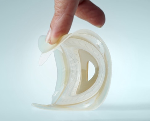 SenSura® Mio Convex klæberen trykkes ned af en finger, så man kan se fleksibiliteten 