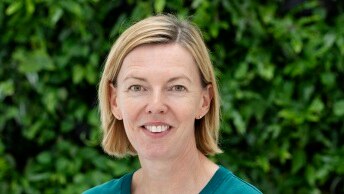 Anne Føns med blå jakke og naturbaggrund